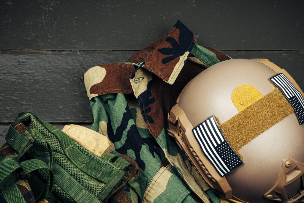 US military armor helmet on wooden background close up