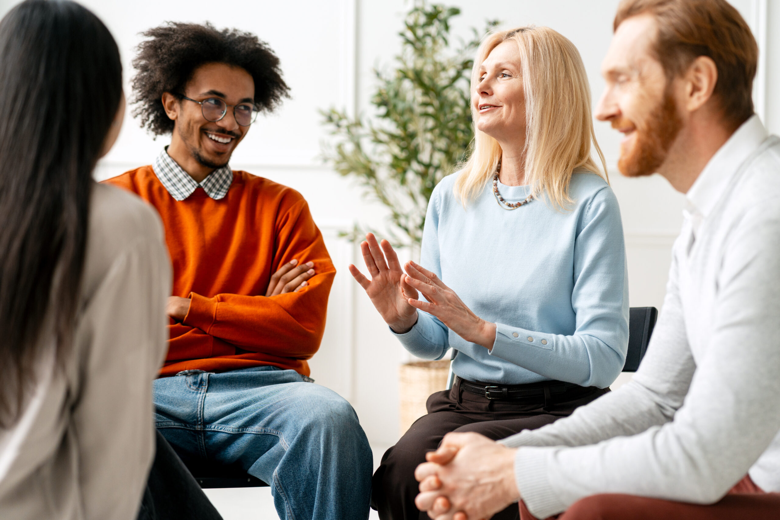Diverse people participating in support group meeting, sharing experiences and communicating in a collaborative environment